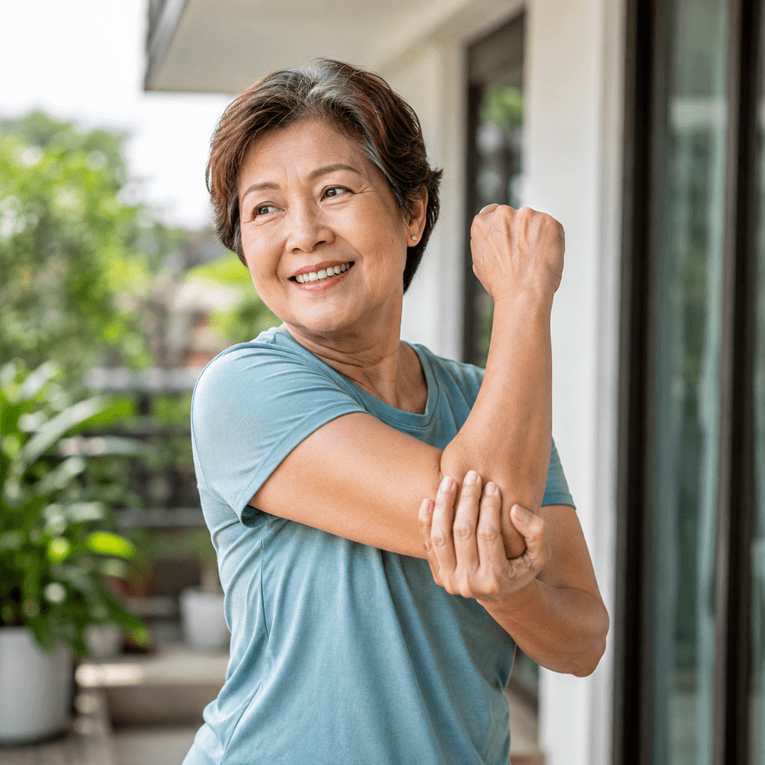 Woman stretching her arm on a sunny balcony at home